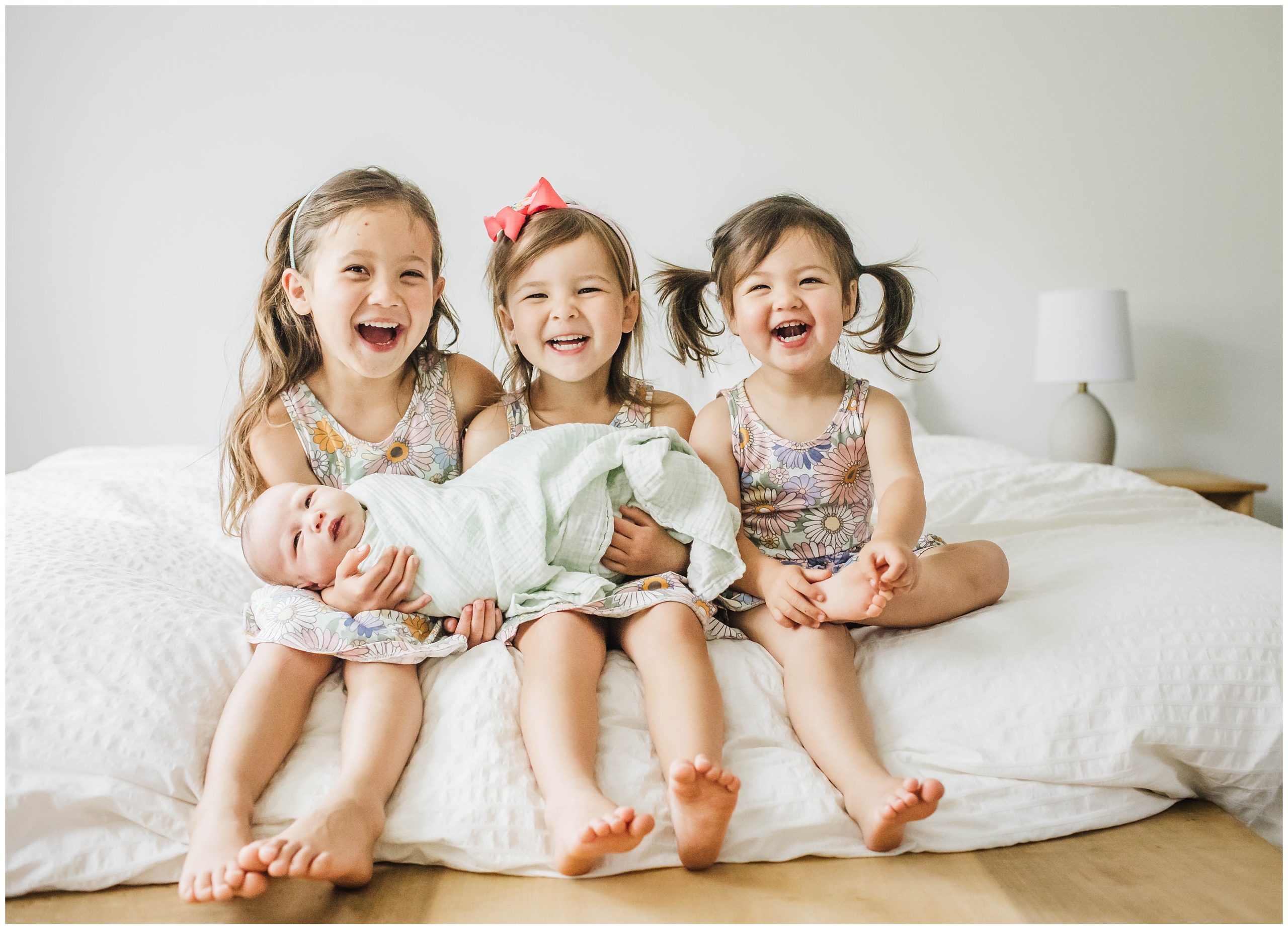 Image of siblings holding baby brother during newborn photoshoot