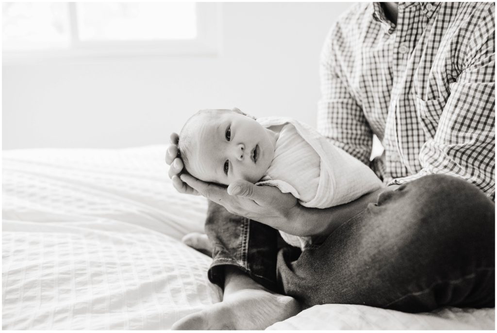 Image depicting a dad holding his son during a newborn photoshoot