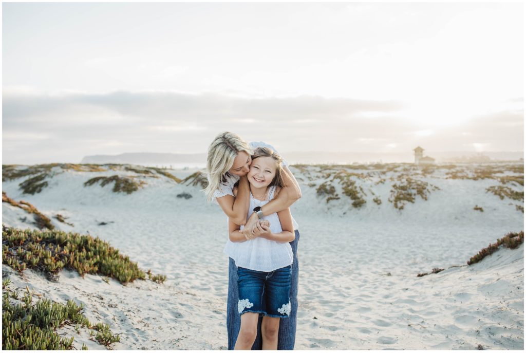 Mom and daughter taking family vacation photos at Coronado Beach